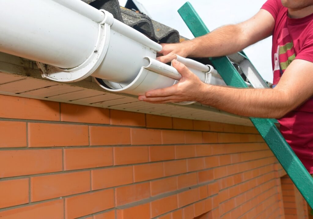 roofer contractor on a ladder is installing, repair, replacing a